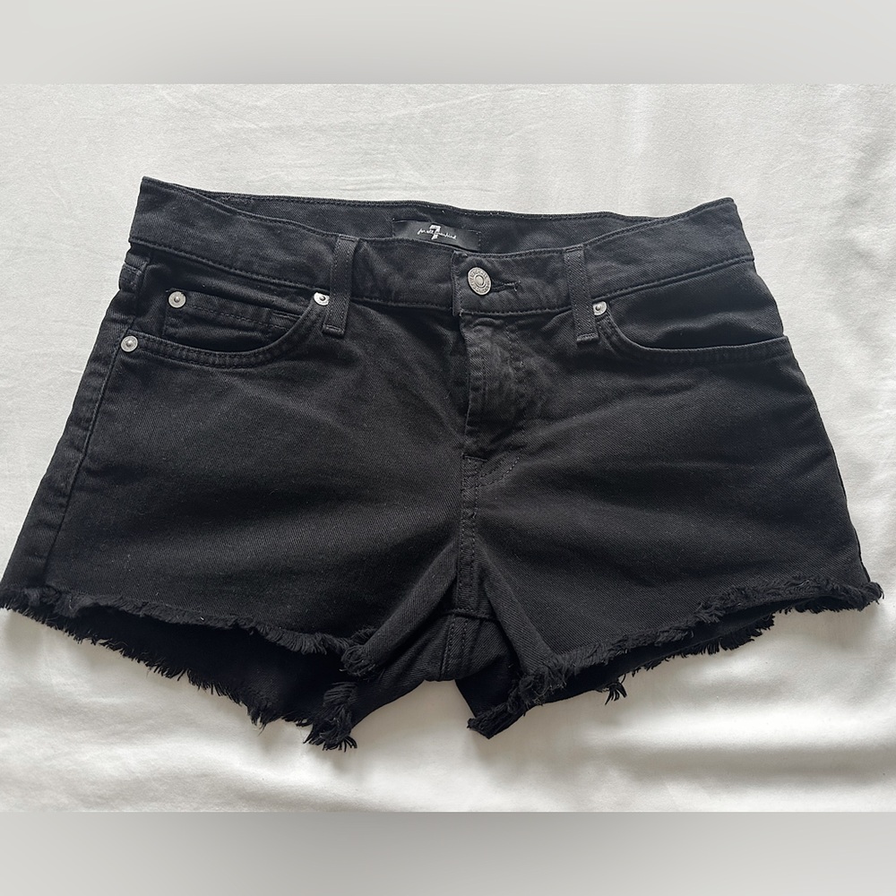 7 For All Mankind low-rise black jean shorts with ruffled hem.
